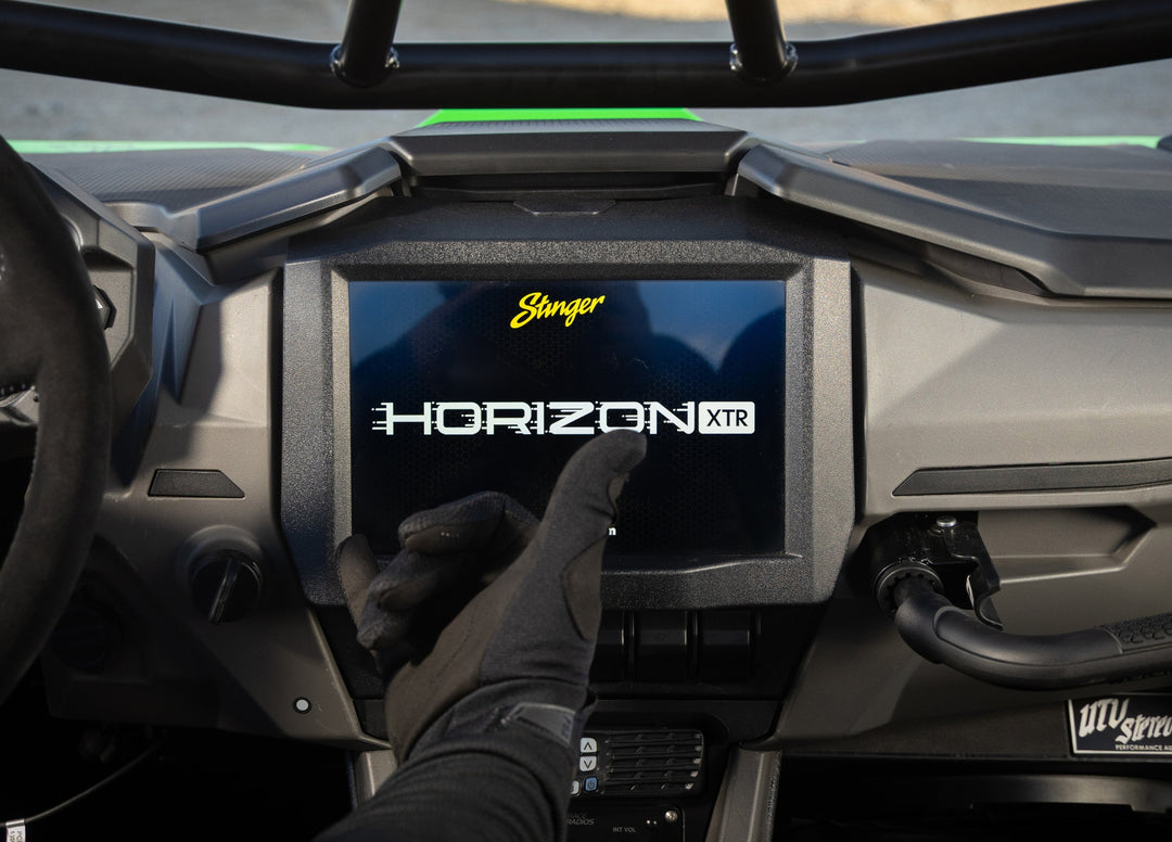 Gloved hand touching Stinger HORIZON XTR screen in UTV dash